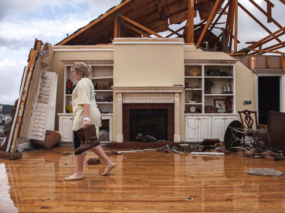 PHOTO: Jenny Bullard carries a pair of boots from her home that was damaged by a tornado, Jan. 22, 2017, in Adel, Georgia.