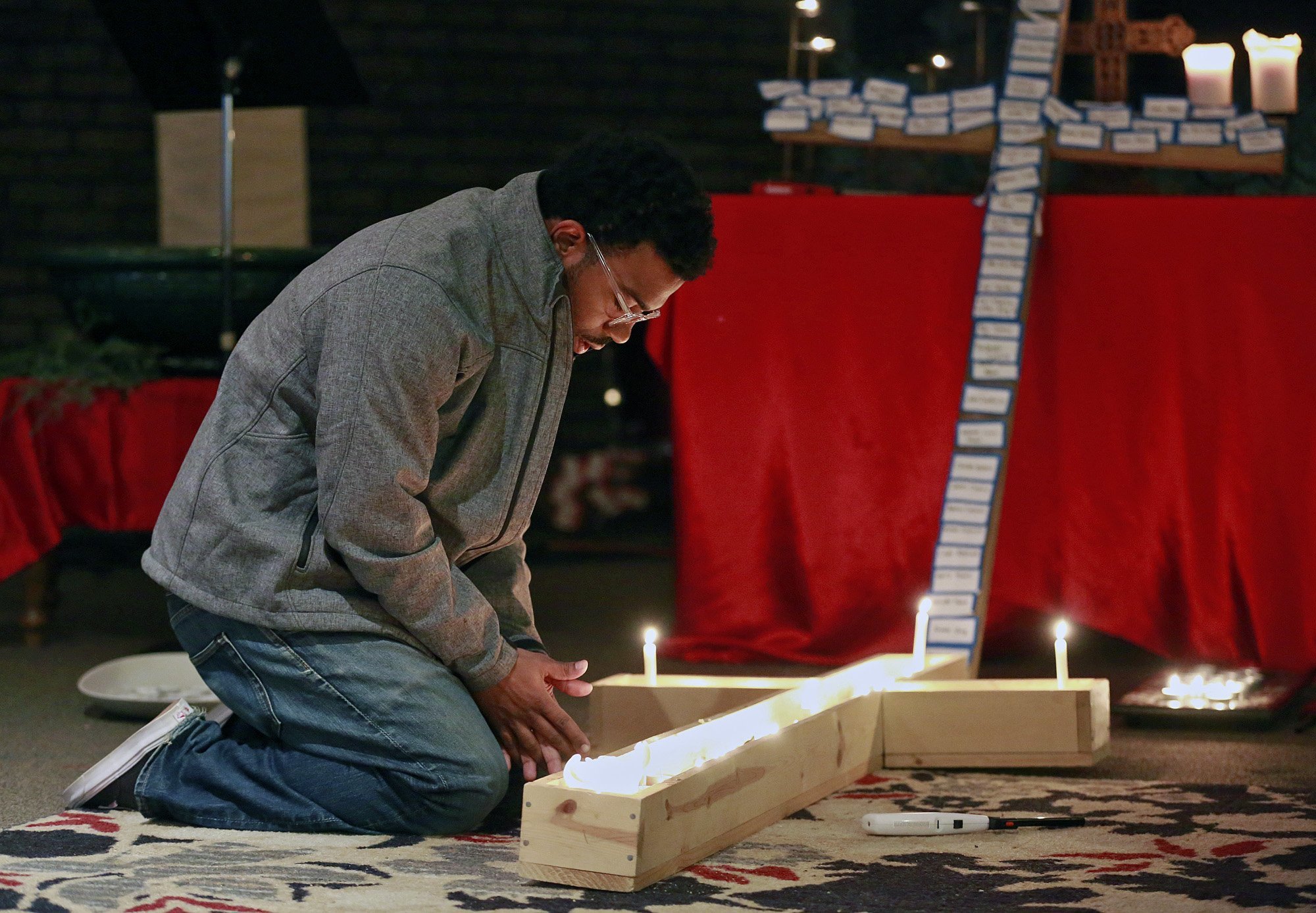 PHOTO: A student lights a candle inside a cross during a vigil at Jacob's Porch, the Lutheran Campus Ministry at Ohio State University in Columbus, Ohio, Nov. 28, 2016.