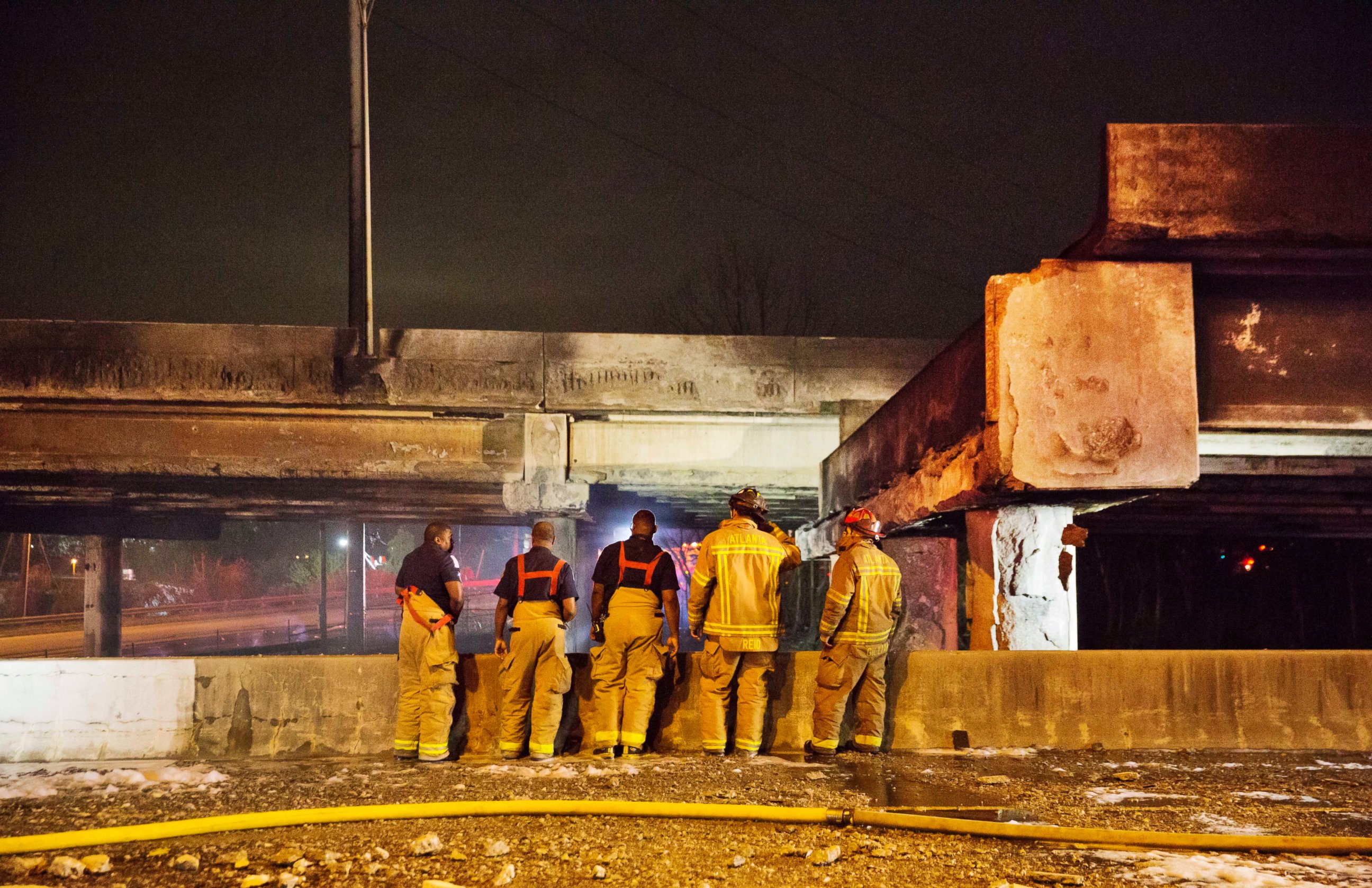 PHOTO: Firefighters survey the section of an overpass that collapsed from a large fire on Interstate 85 in Atlanta, March 30, 2017. 