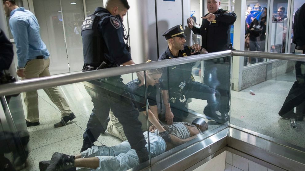 New York City police officers detain a passenger from a disabled New Jersey Transit train who became belligerent and sparked a stampede among passengers leaving the overcrowded station once the train finally arrived at New York's Penn Station, April 14, 2017.