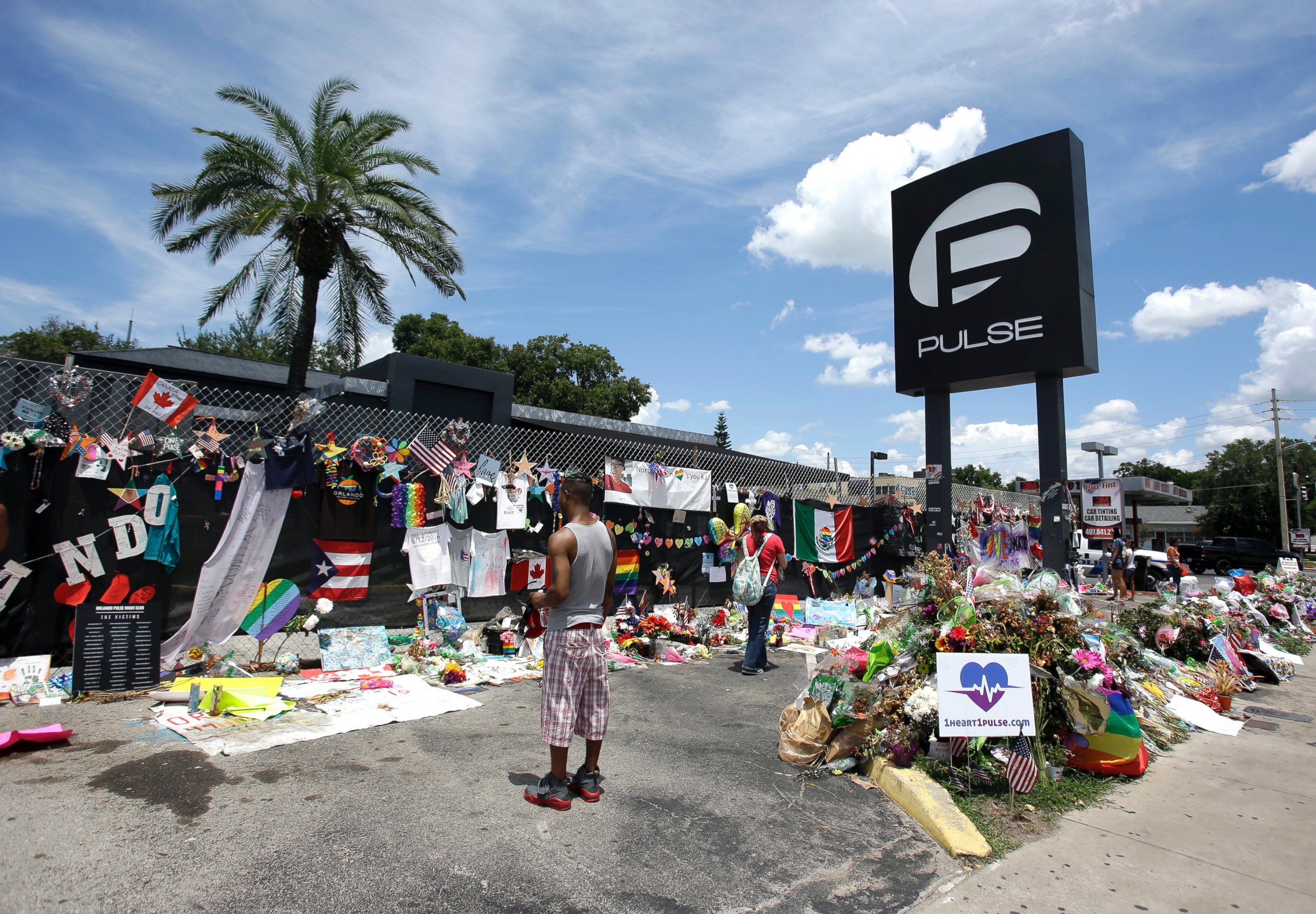 PHOTO: In this July 11, 2016, file photo, visitors at a makeshift memorial outside the Pulse nightclub, the day before the one month anniversary of the mass shooting, in Orlando, Fla.