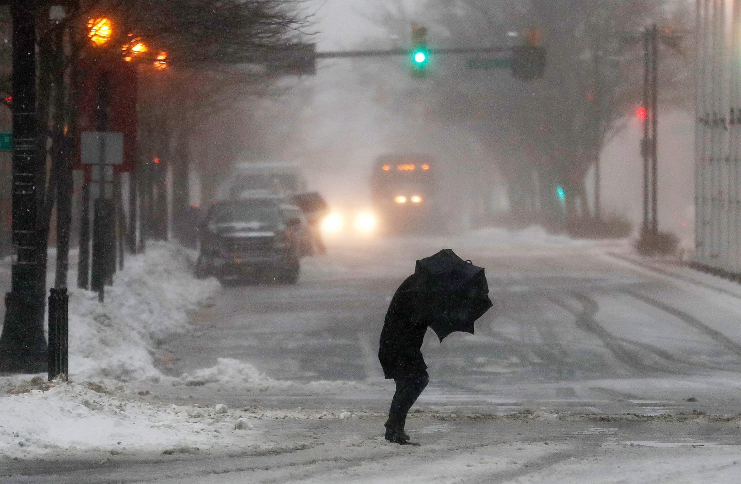 PHOTO: A person hunches while walking against strong winds in Jersey City, N.J., during a snowstorm, March 14, 2017.