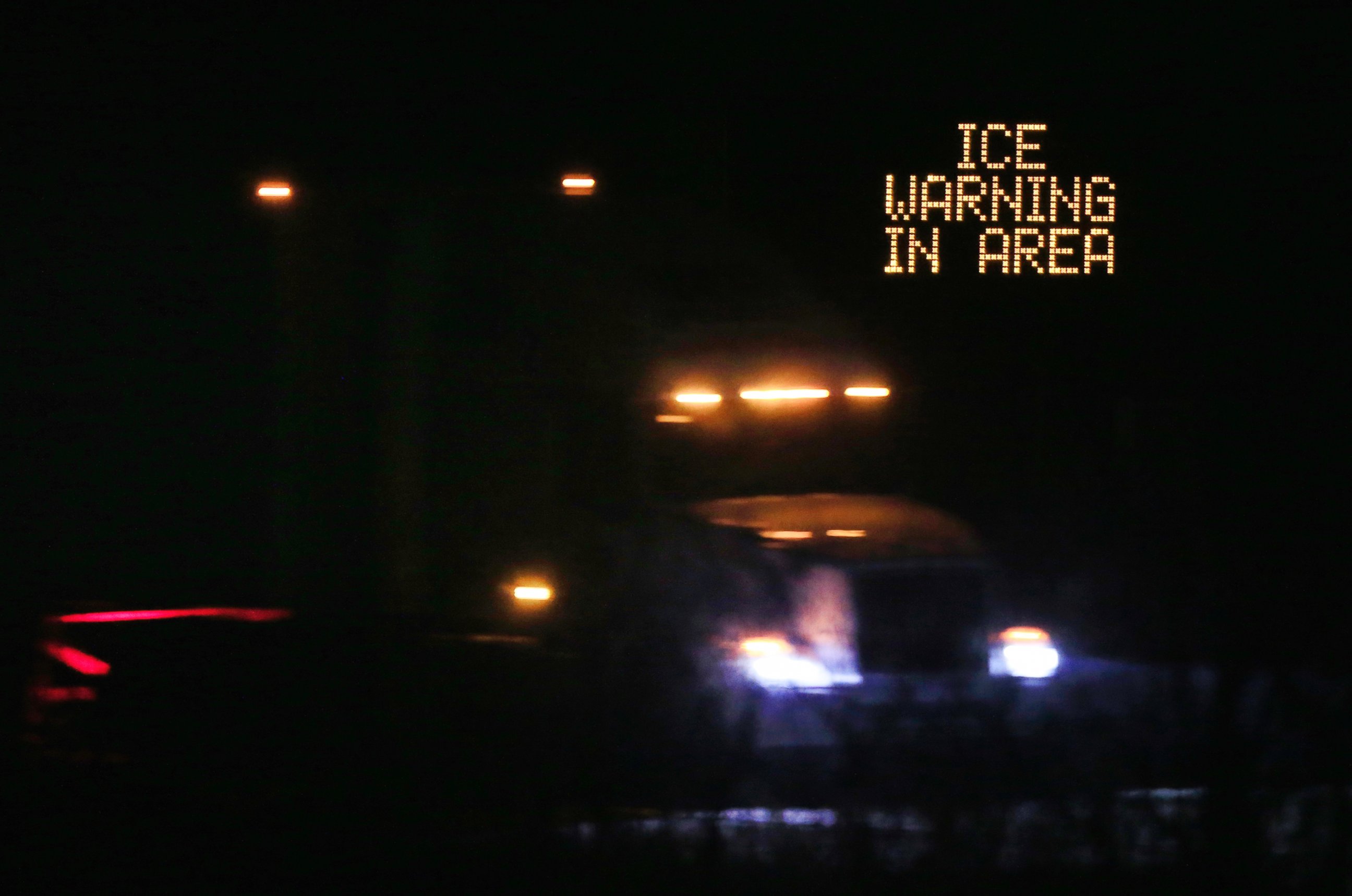 PHOTO: Traffic moves past an icing warning sign at night on I-70 west Lawrence, Kansas, Jan. 14, 2017. 