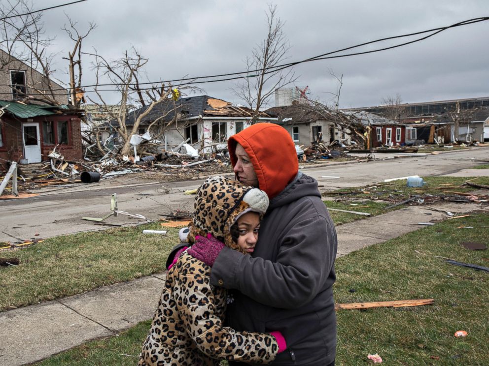 PHOTO: Valerie McAvoy and daughter Jayda Weathersby, 9, hug as they survey the tornado damage to their neighborhood, March 1, 2017, in Naplate, Ill.