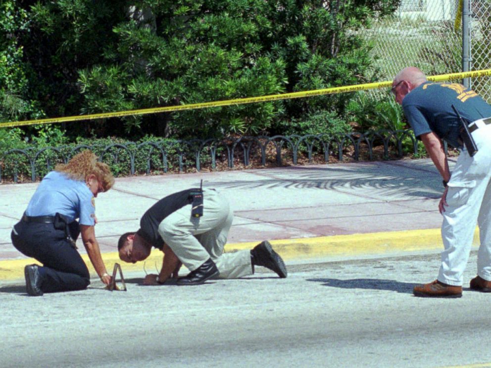 PHOTO: Detectives comb the ground for clues outside the home of slain Italian fashion designer Gianni Versace, July 15, 1997, in Miami Beach.