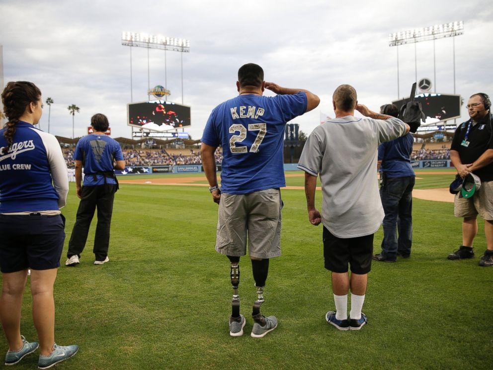 PHOTO: U.S. Army veteran Wesley Barrientos, center, who lost his legs in 2007 while serving in Iraq, listens to the national anthem before a baseball game between the Los Angeles Dodgers and the Arizona Diamondbacks, June 9, 2015, in Los Angeles.