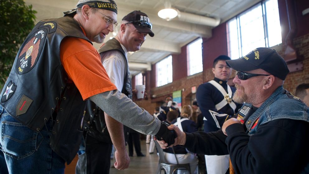 Joel Funk, of Salem, left, and Steve Lovelace, of Botetourt, center, both with the American Legion Riders, greet Vietnam War veteran Charles Shull of Roanoke prior to Virginia's Veterans Parade, Nov. 5, 2016, during a meet and greet at the City Market building in Roanoke, Virginia.