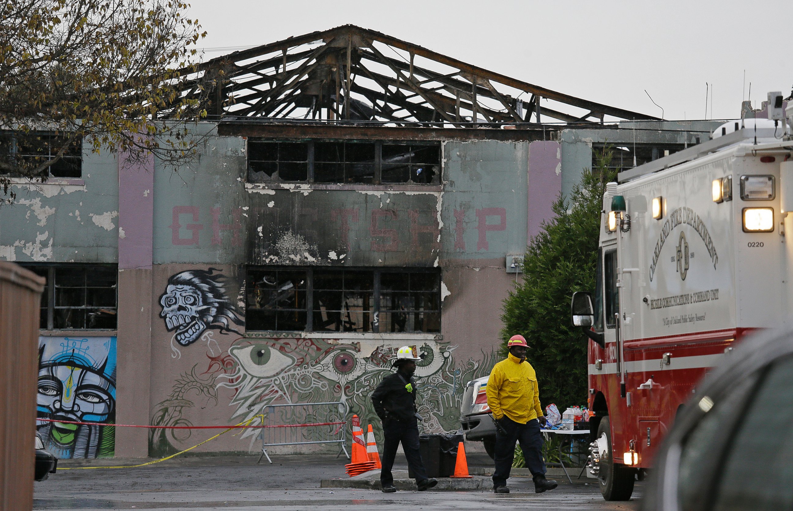 PHOTO: A pair of Oakland fire officials walk past the remains of the Ghost Ship warehouse fire, Dec. 7, 2016, in Oakland, California. 