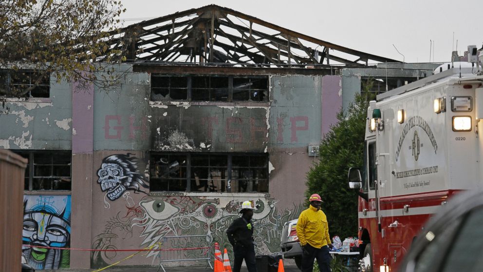 A pair of Oakland fire officials walk past the remains of the Ghost Ship warehouse fire, Dec. 7, 2016, in Oakland, California.