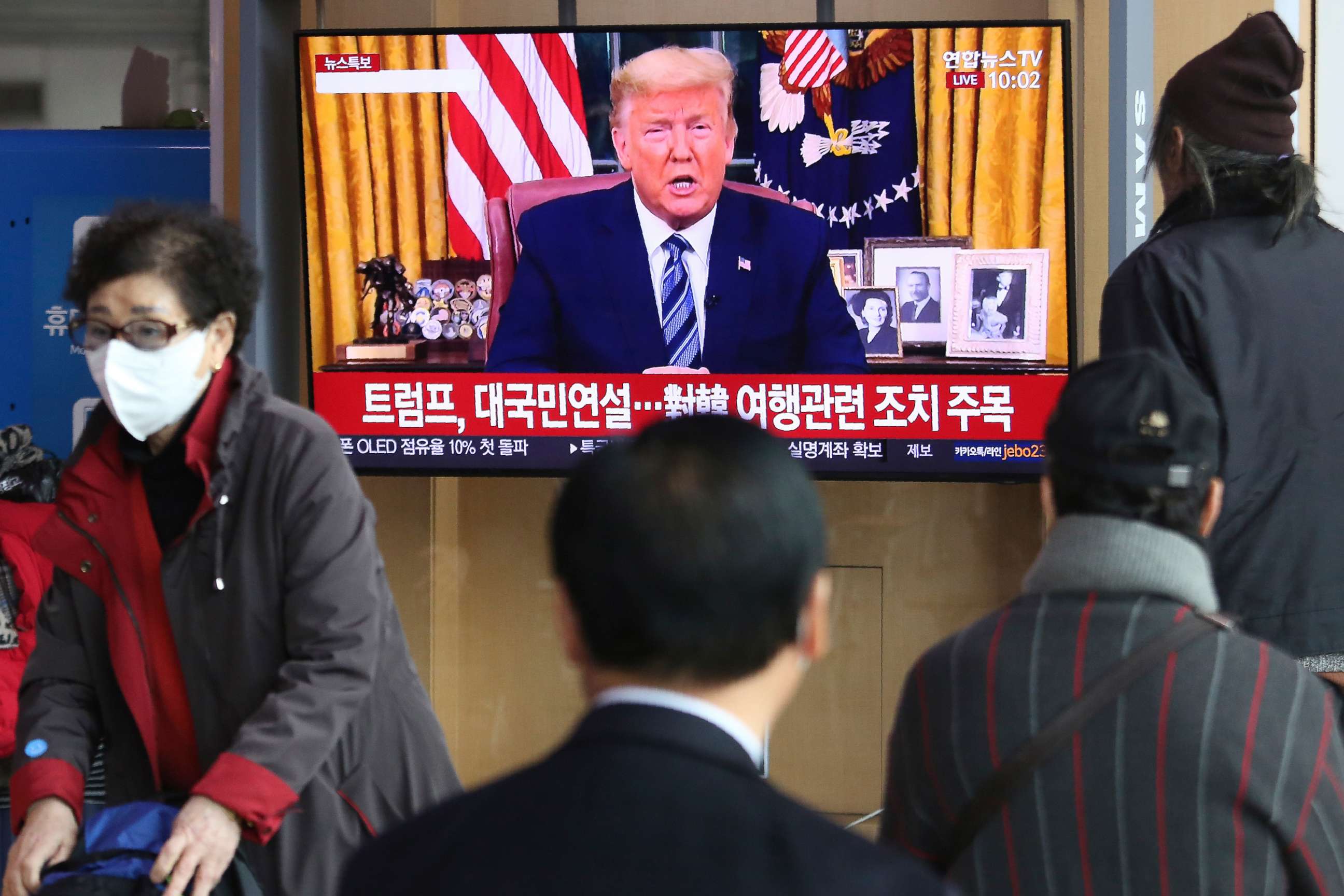 PHOTO: People watch a TV screen showing a live broadcast of U.S. President Donald Trump's speech at the Seoul Railway Station in Seoul, South Korea, Thursday, March 12, 2020. Trump announced he is cutting off travel from Europe to the U.S.