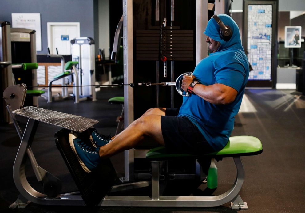 PHOTO: Ruben Munoz uses the seated rowing machine during his workout at Flex 24 in Odessa, Texas, Monday, May 18, 2020. As a precaution, the gym requires all gym-goers to disinfect machines before and after each use to prevent the spread of coronavirus. 