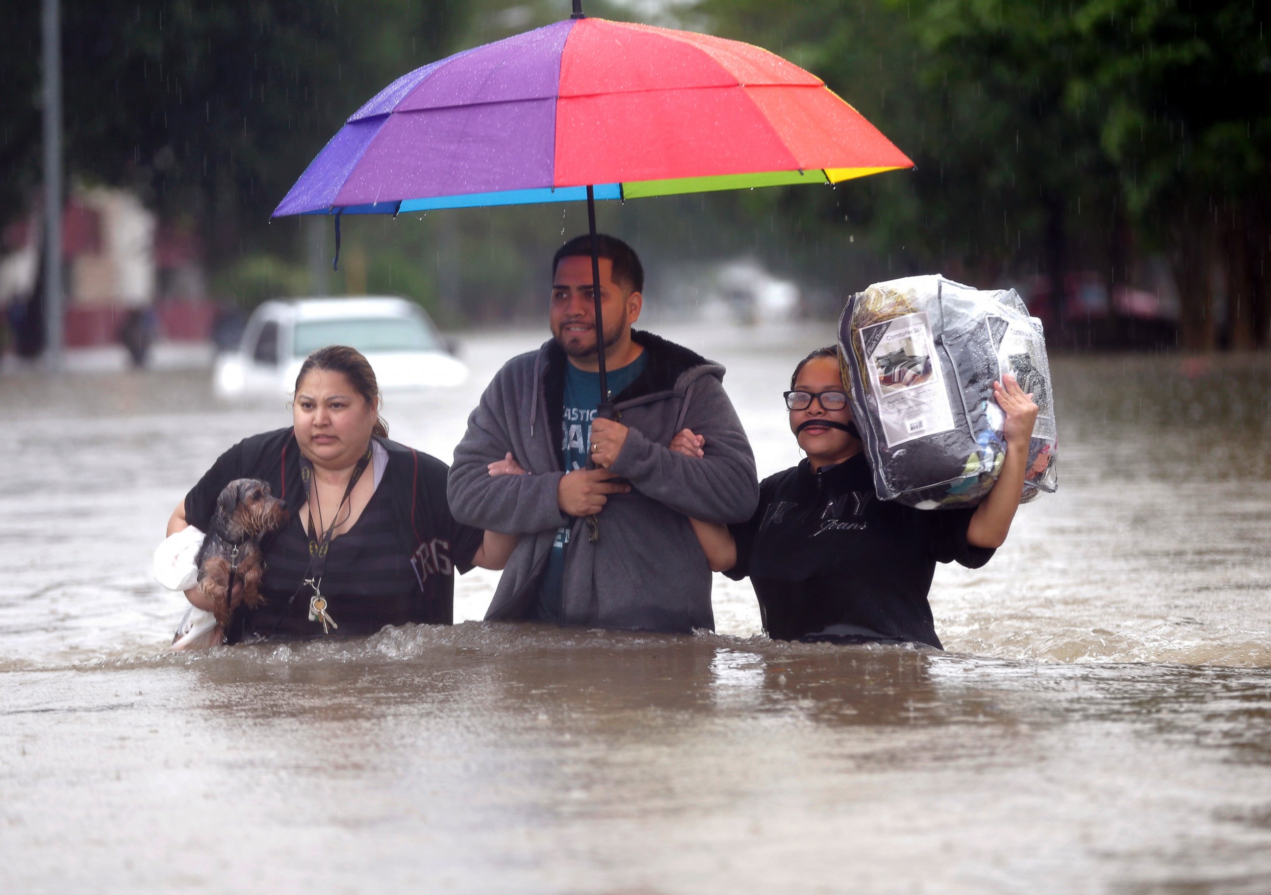 PHOTO: Felix Yanez, center, helps Lucy Olvio, right, and Judy wade through floodwaters as they evacuate from their flooded apartment complex, April 18, 2016, in Houston. 