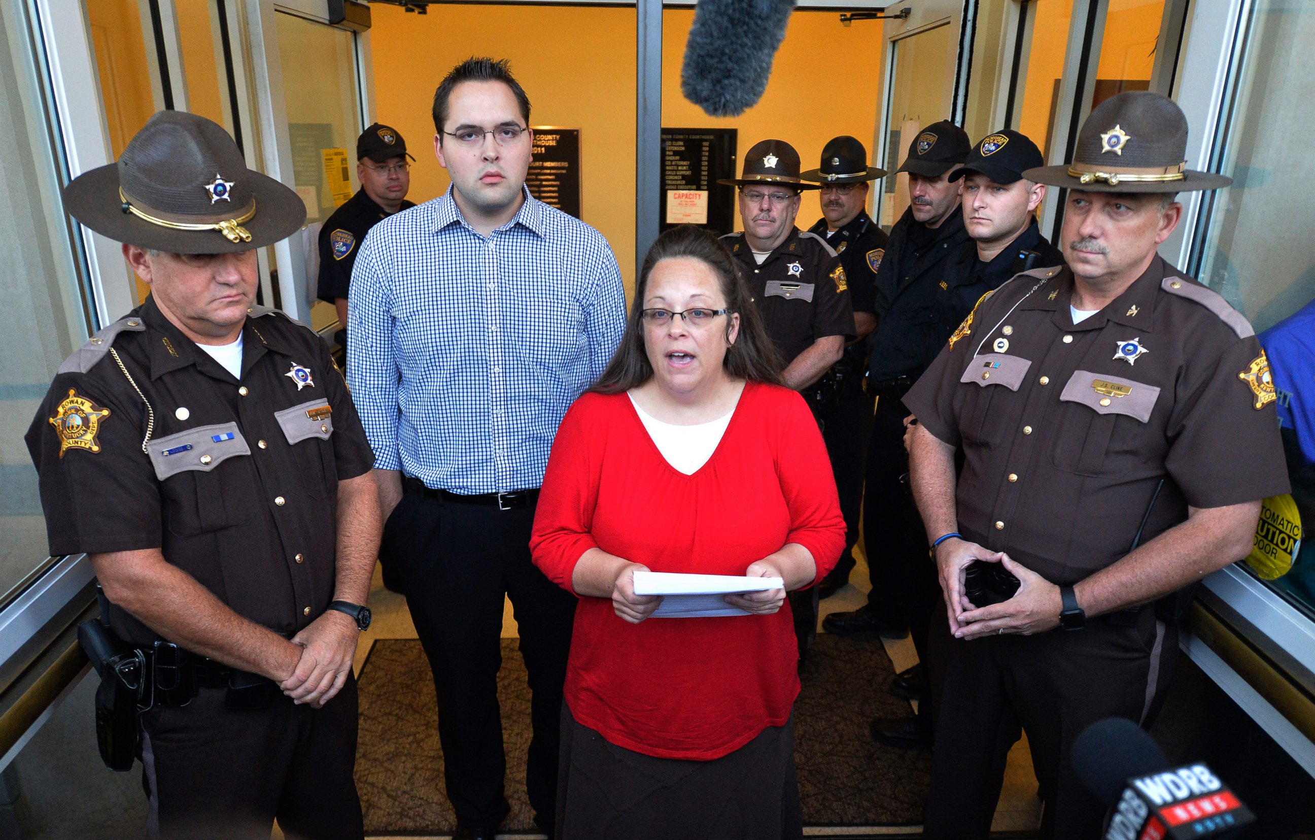 PHOTO: Surrounded by Rowan County Sheriff's deputies, Rowan County Clerk Kim Davis, center, with her son Nathan Davis standing by her side, makes a statement to the media at the front door of the Rowan County Judicial Center in Morehead, Ky.