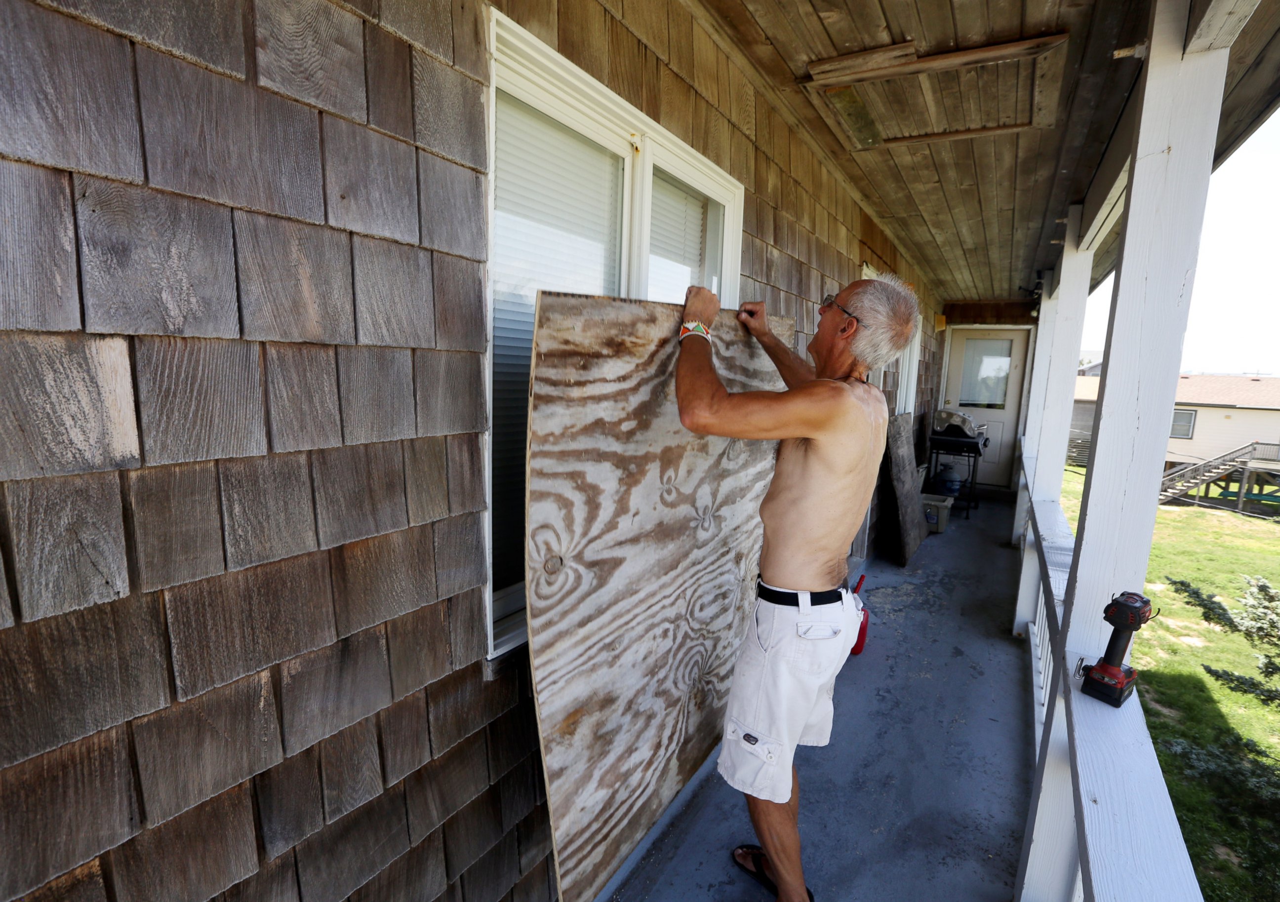 PHOTO: Peter LeWando puts plywood sheets over the windows of his apartment in Avon, N.C., July 3, 2014.