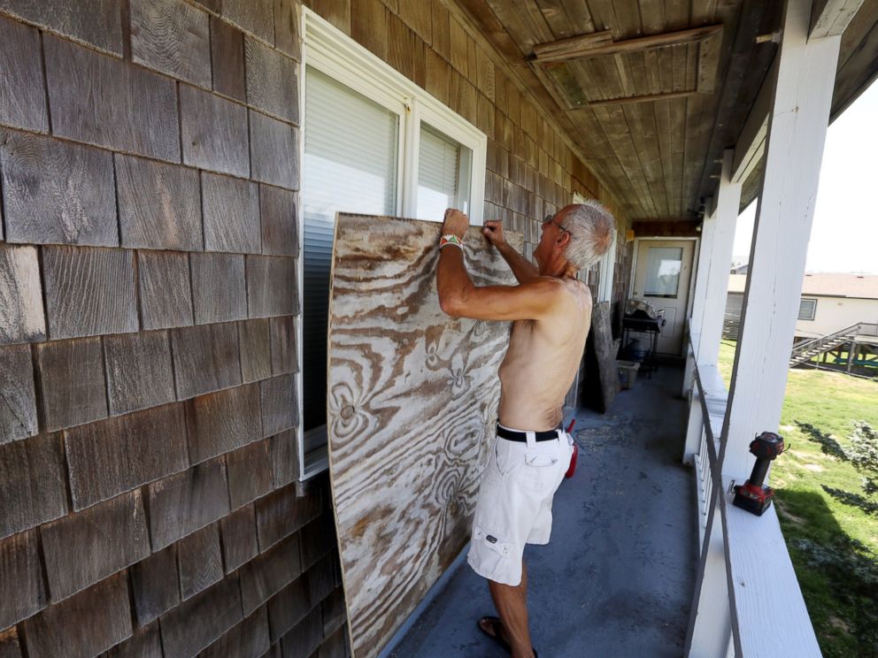 PHOTO: Peter LeWando puts plywood sheets over the windows of his apartment in Avon, N.C., July 3, 2014.