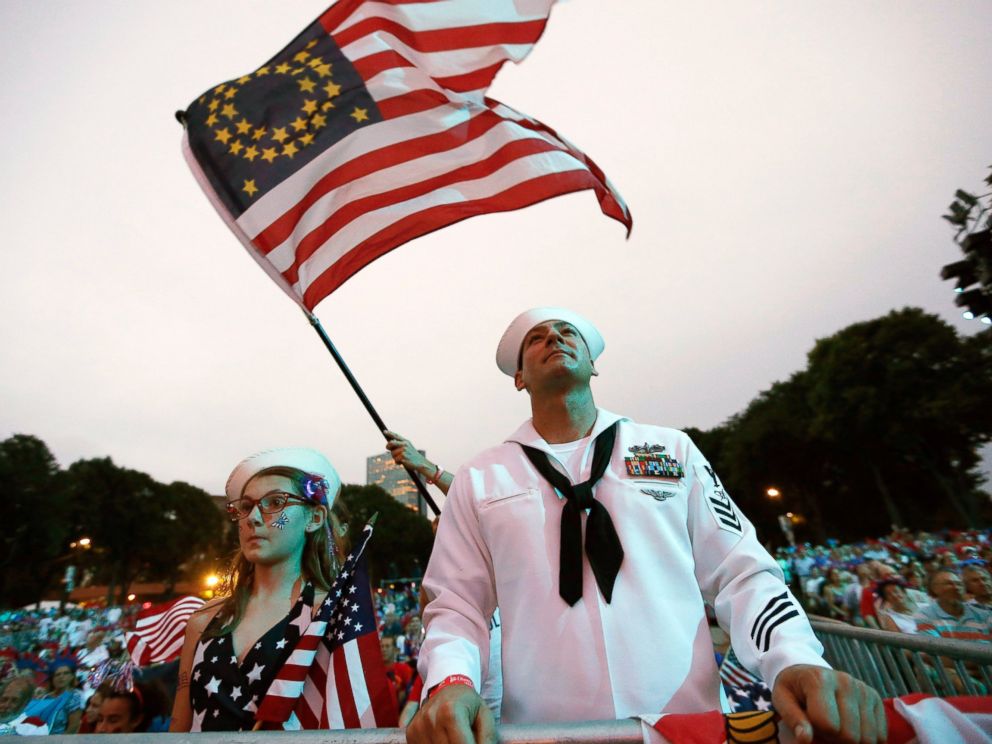 PHOTO: Petty Officer 1st Class Jason Thompson, right, of Detroit, and Megan Schinker, 13, of Stow, Ohio, watch a reading by Massachusetts Gov. Deval Patrick during a concert at the Hatch Shell on the Esplanade in Boston, July 3, 2014.