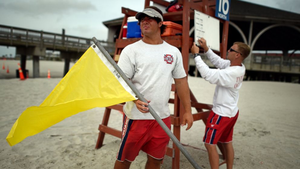 PHOTO: Tybee Island Ocean Rescue Senior Lifeguard Todd Horne, right, and Mark Eichenlaub, left, prepare to hang a yellow flag that warns swimmers of strong rip currents from Hurricane Arthur along the beach on Tybee Island, Ga., July 3, 2014.