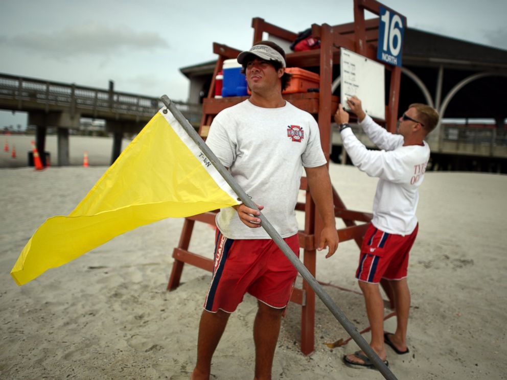 PHOTO: Tybee Island Ocean Rescue Senior Lifeguard Todd Horne, right, and Mark Eichenlaub, left, prepare to hang a yellow flag that warns swimmers of strong rip currents from Hurricane Arthur along the beach on Tybee Island, Ga., July 3, 2014.