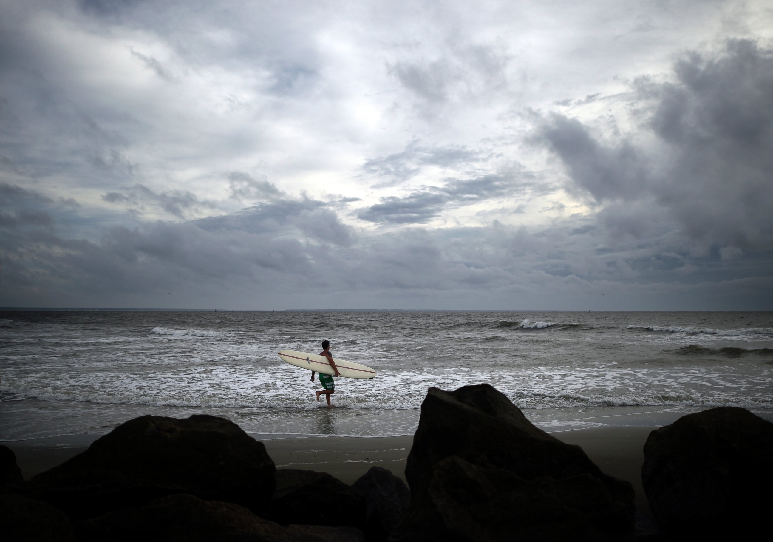 PHOTO: Kevin Taylor of Savannah, Ga., heads out to surf the waves on the north beach of Tybee Island as Hurricane Arthur makes its way up the East Coast, July 3, 2014.