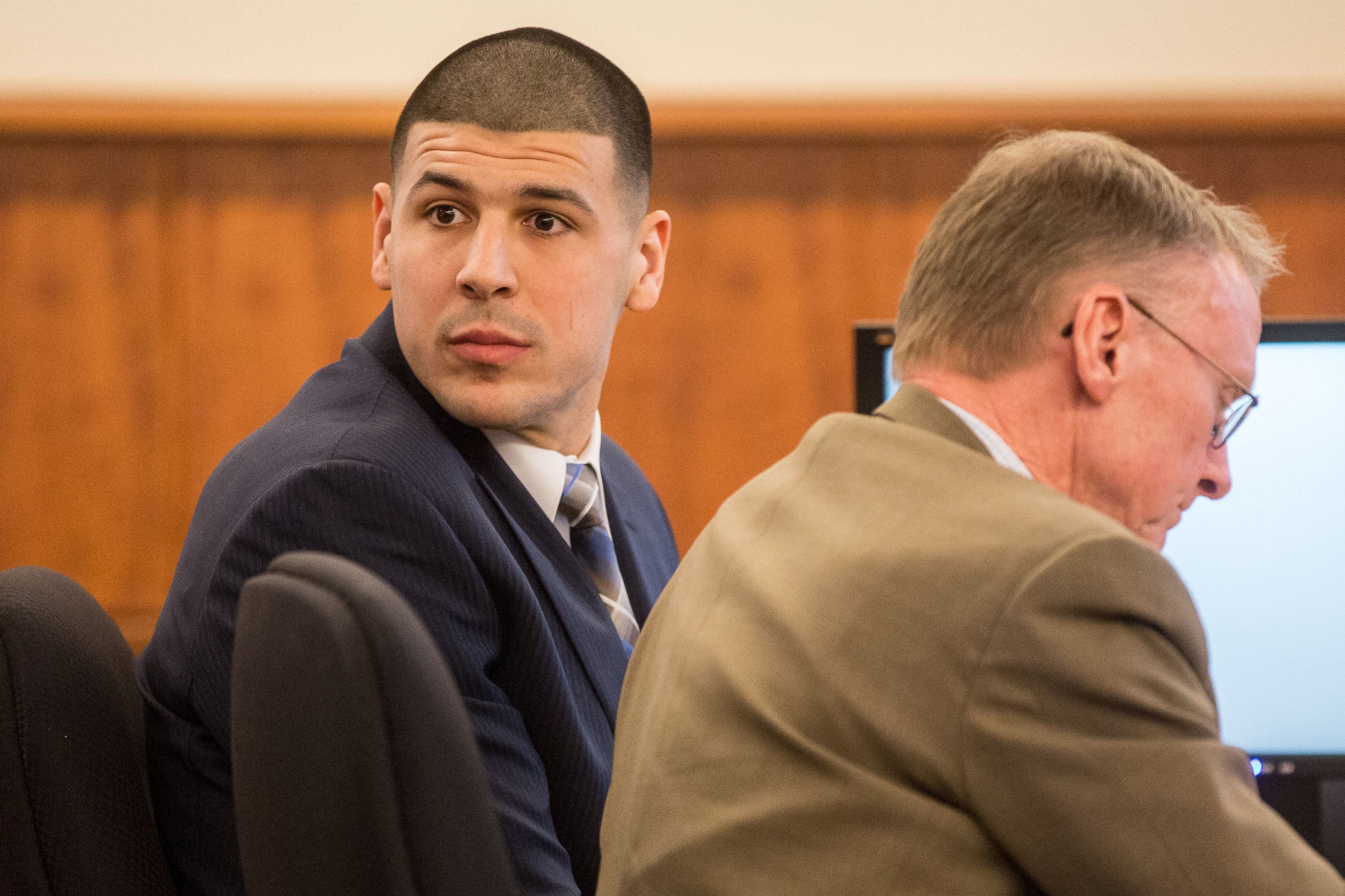 PHOTO: Former New England Patriots football player Aaron Hernandez, left, looks back as he sits with his attorney Charles Rankin during his murder trial, Feb. 13, 2015, in Fall River, Mass.