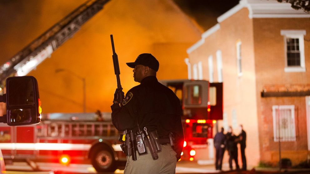 An officer stands near a fire in Baltimore, April 27, 2015, amid violence in the city.