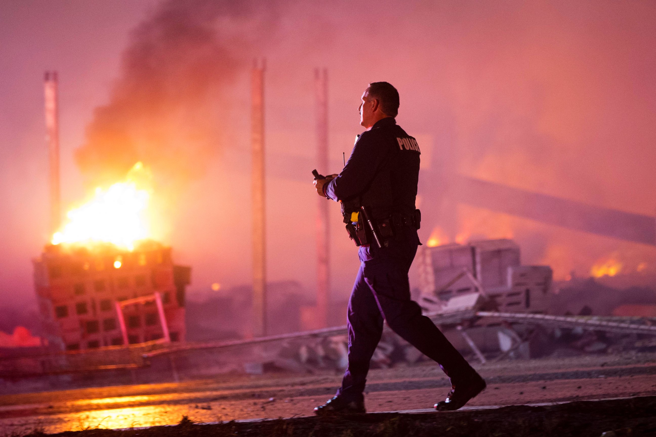 PHOTO: A police officer walks by a blaze, April 27, 2015, after violence broke out in Baltimore.