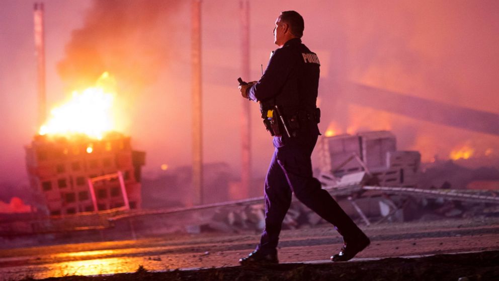 PHOTO: A police officer walks by a blaze, April 27, 2015, after violence broke out in Baltimore.