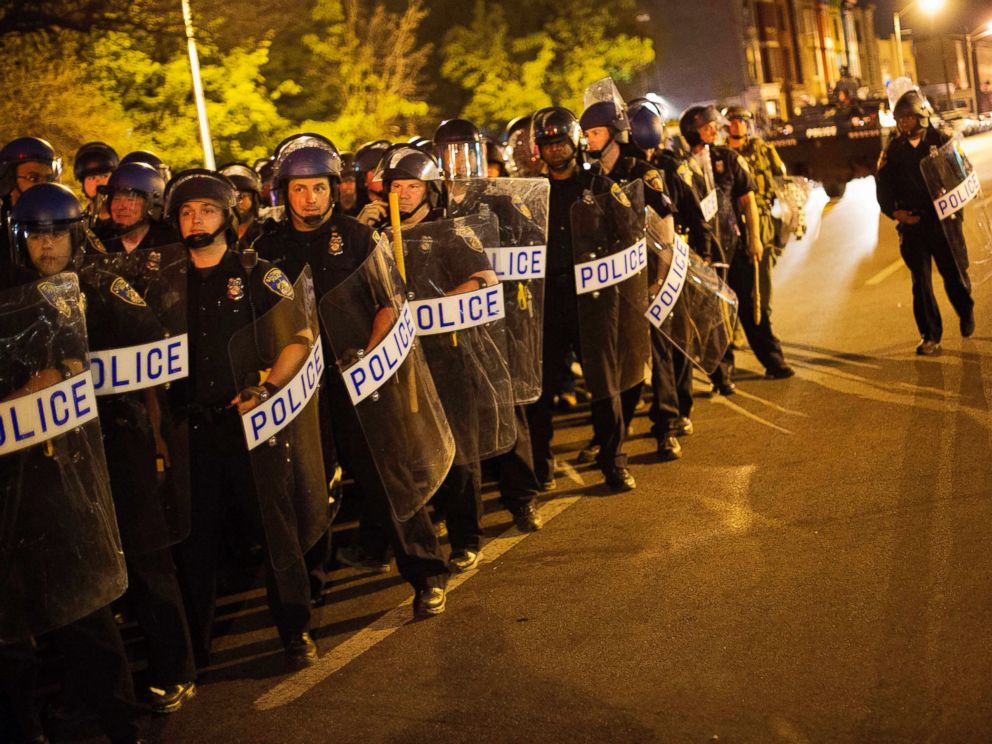 PHOTO: Police in riot gear line up near the scene of Mondays riots ahead of a 10 p.m. curfew, April 29, 2015, in Baltimore.