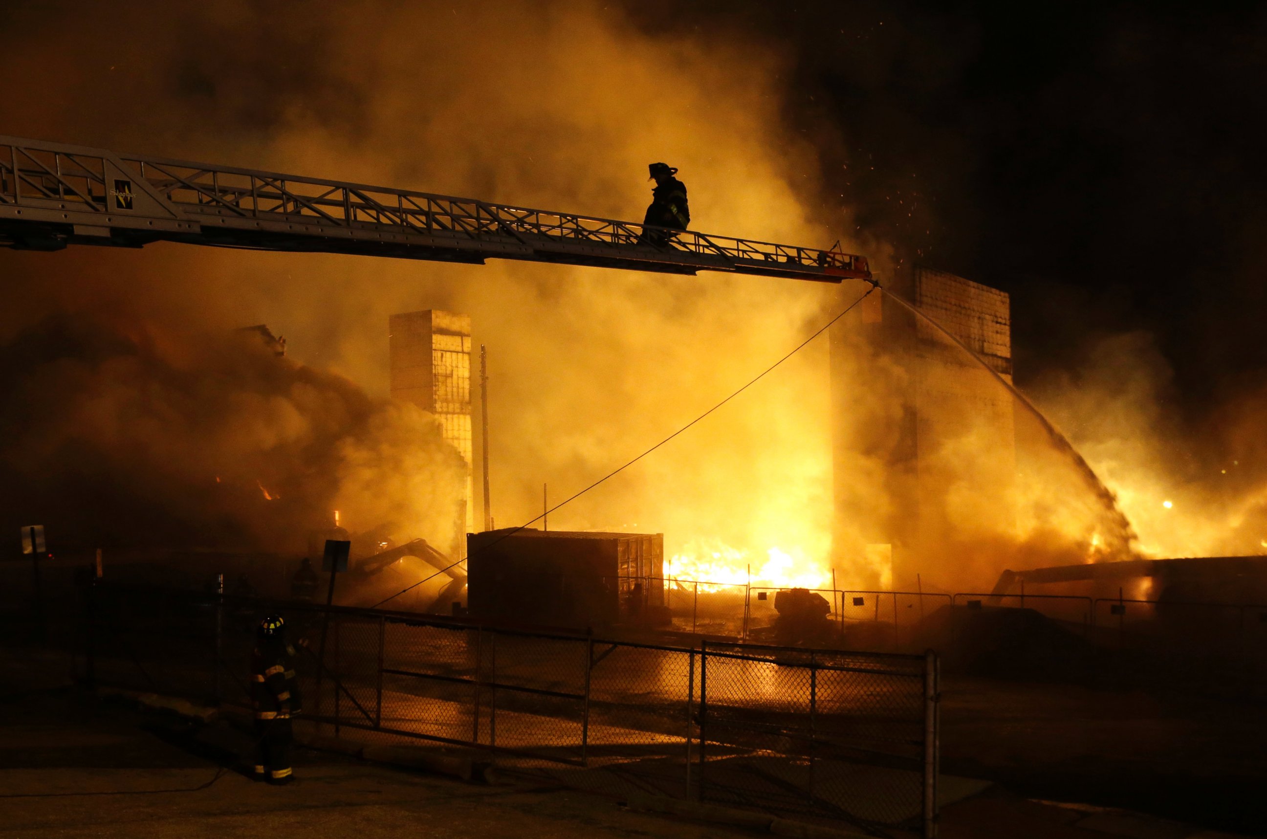 Firefighters battle a blaze, Monday, April 27, 2015, after rioters plunged part of Baltimore into chaos, torching a pharmacy, setting police cars ablaze and throwing bricks at officers.