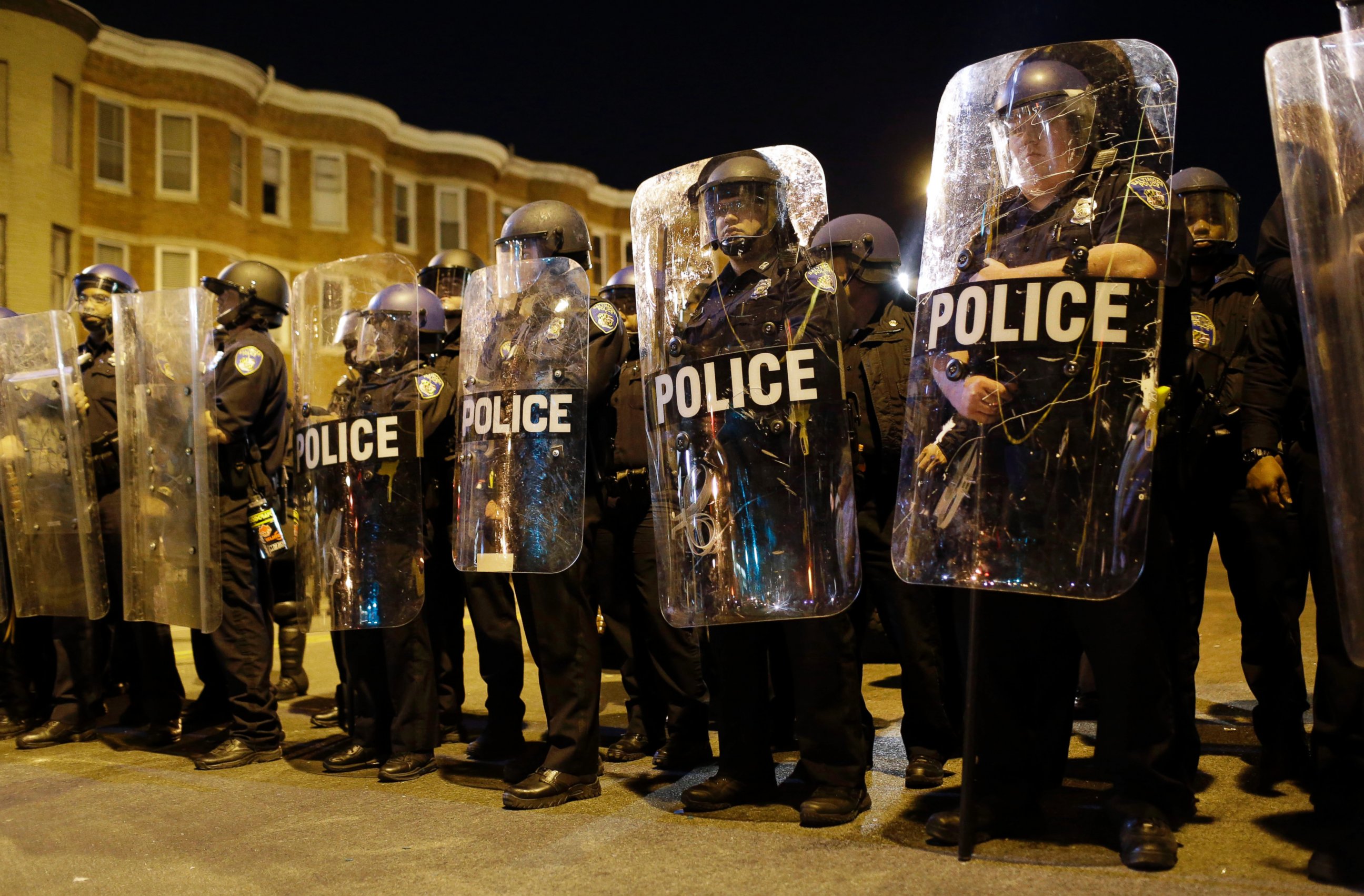 Police stand in formation as a curfew approaches, Tuesday, April 28, 2015, in Baltimore, a day after unrest that occurred following Freddie Gray's funeral.