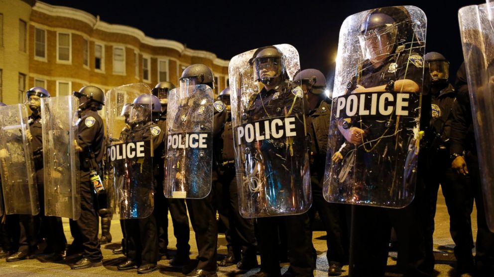Police stand in formation as a curfew approaches, Tuesday, April 28, 2015, in Baltimore, a day after unrest that occurred following Freddie Gray's funeral.