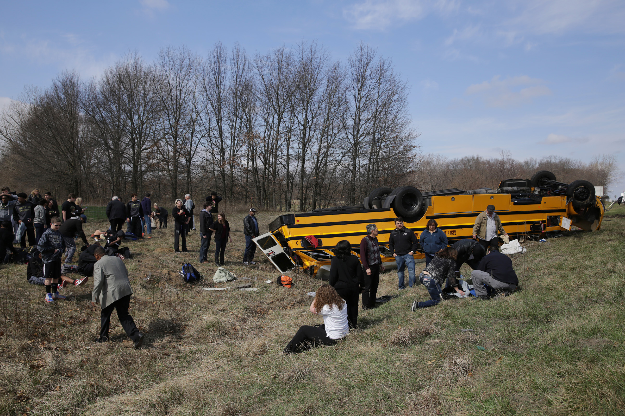 PHOTO:People on the scene of a school bus accident attend to the injured after the bus carrying Griffith High boys basketball team overturned in Demotte, Ind., March 19, 2016.  