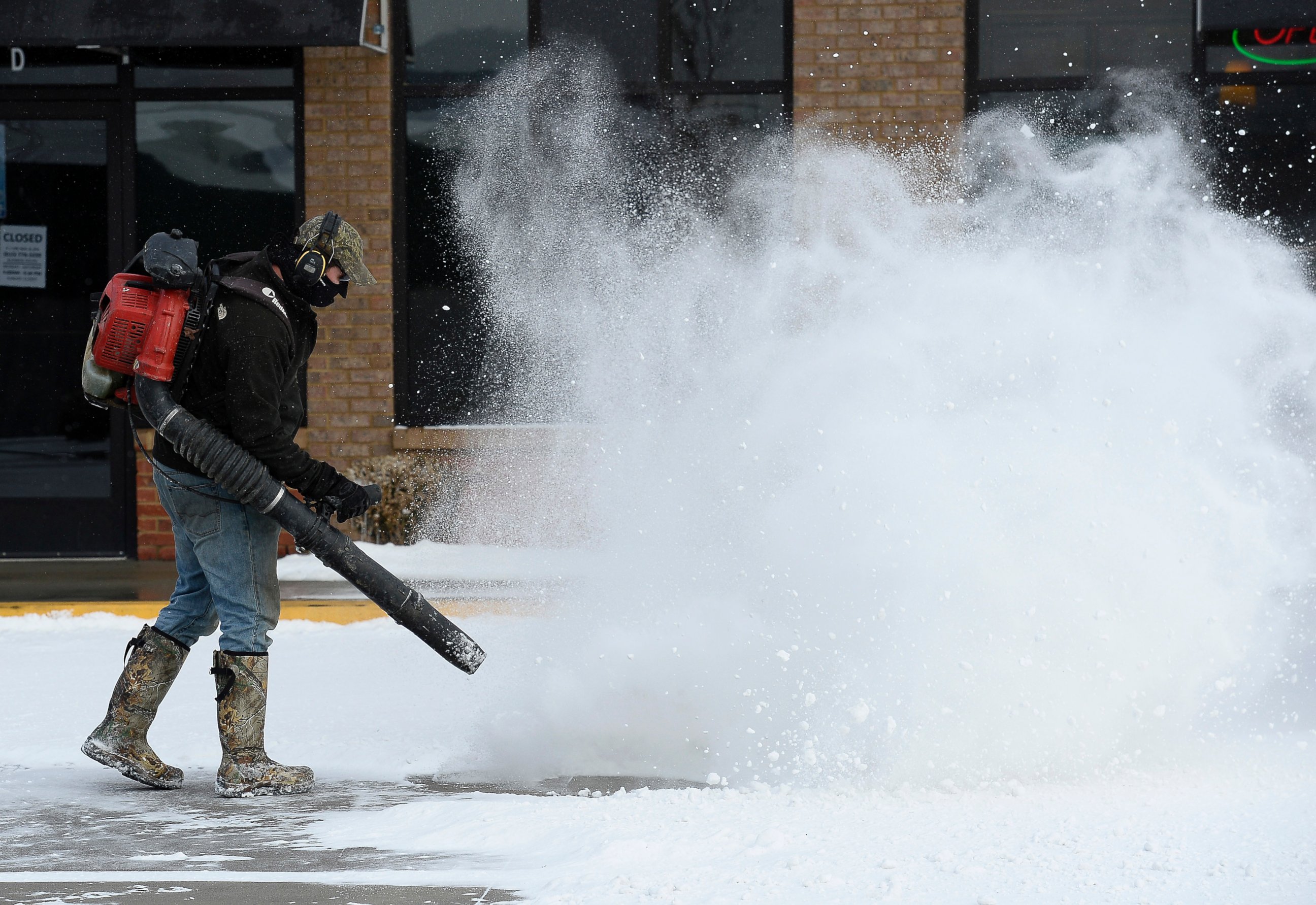 PHOTO: Will Scott uses a blower to remove snow from a parking lot, Feb. 18, 2015, in Nolensville, Tenn.