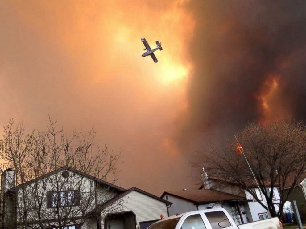 PHOTO: Smoke fills the air as a small plane flies overhead in Fort McMurray, Alberta, May 3, 2016. The entire population of the Canadian oil sands city has been ordered to evacuate as a wildfire engulfed homes and sent ash raining down on residents.