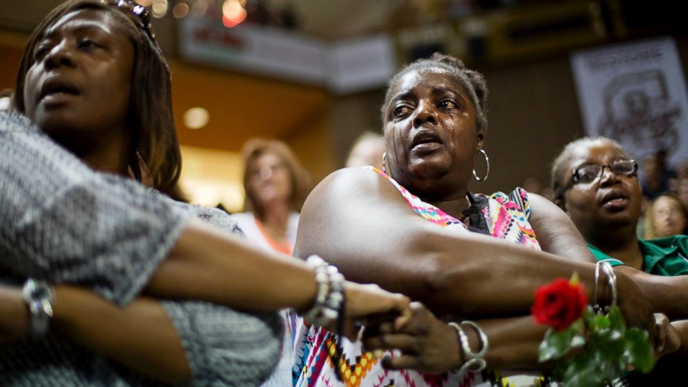 Barbara Lloyd, of Charleston, S.C., cries as she joins hands with mourners during the singing of "We Shall Overcome" at a memorial service for the victims of the shooting at Emanuel AME Church, Friday, June 19, 2015, in Charleston, S.C. 