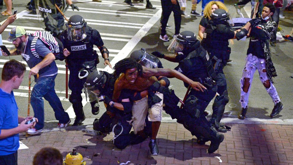 A protester, center, is taken into custody by Charlotte-Mecklenburg police officers in Charlotte, North Carolina,  Sept. 21, 2016.