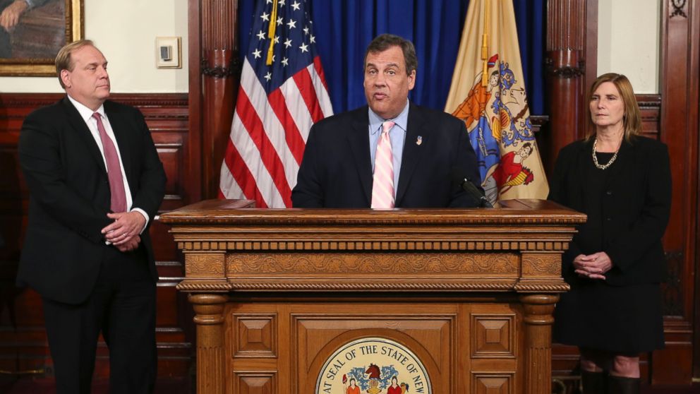 New Jersey Department of Education commissioner David C. Hespe, left, and acting health commissioner Cathleen Bennett, right, listen as New Jersey Gov. Chris Christie, center, announces that he will require all of the state's schools to test for lead in water starting next school year, May 2, 2016, in Trenton, N.J. 