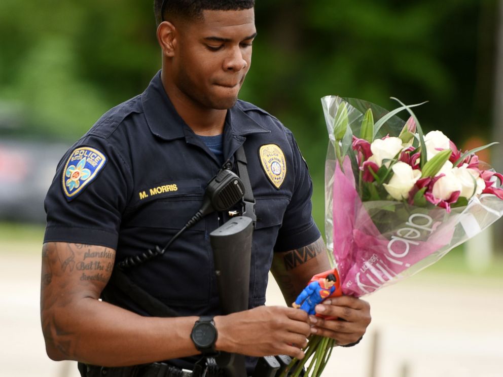 PHOTO: Baton Rouge Police Department Officer Markell Morris holds a bouquet of flowers and a Superman action figure that a citizen left at the Our Lady of the Lake Hospital where the police officers were brought this morning, July 17, 2016. 