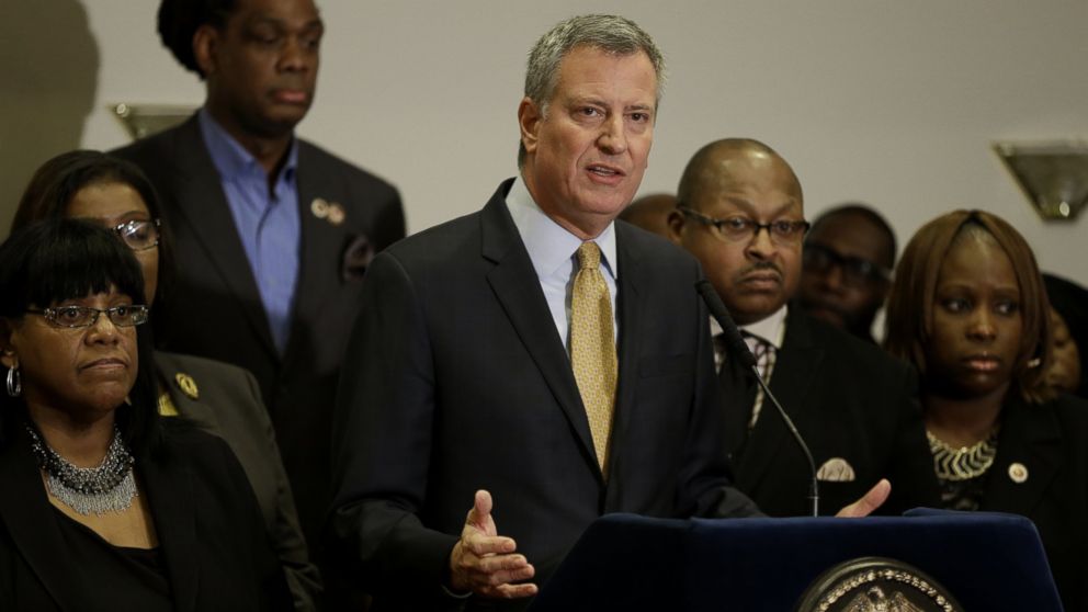 New York City Mayor Bill de Blasio, surrounded by community leaders, speaks to reporters about the grand jury's decision in the Eric Garner case in the borough of Staten Island in New York, Dec. 3, 2014.