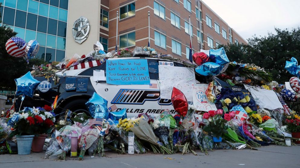 PHOTO: Two Dallas police patrol cars are covered with notes, flowers, balloons and other items as part of a makeshift memorial at the headquarters, July 10, 2016, in Dallas.