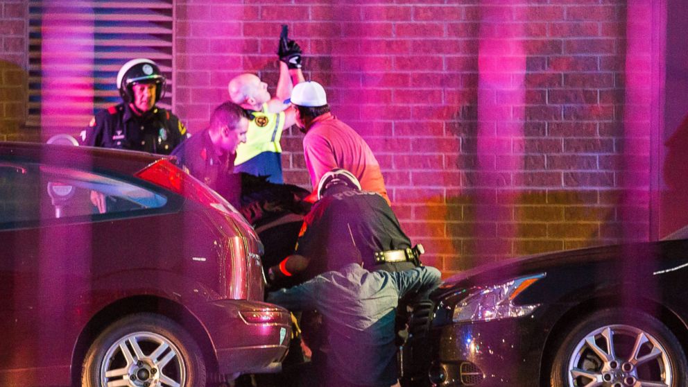 Dallas Police shield bystanders after shots were fired, July 7, 2016, during a protest over two recent fatal police shootings of black men.