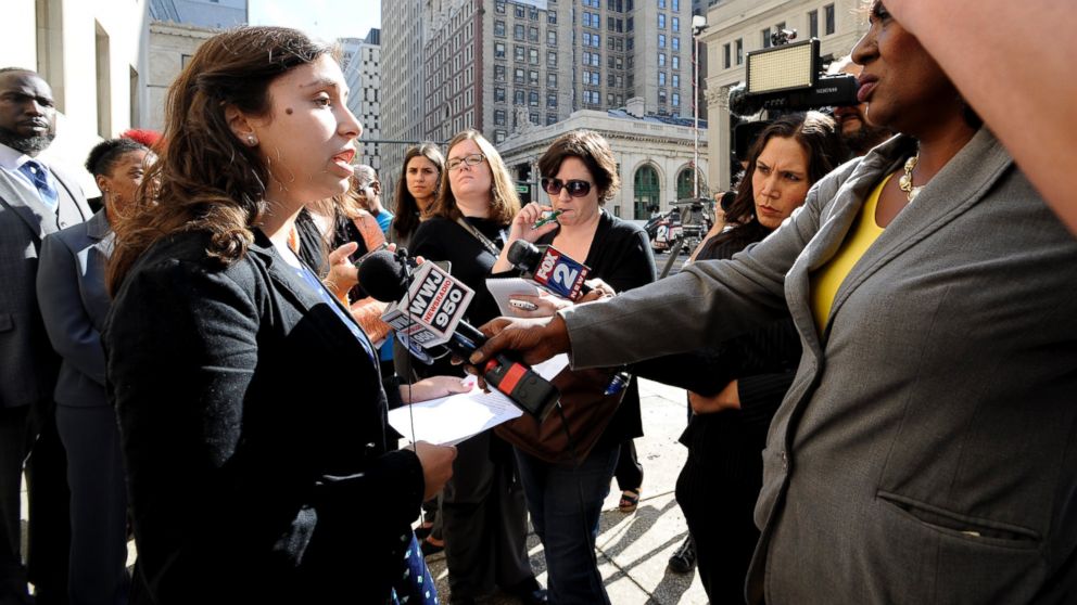 Renee Schenkman, a former teacher at Experiencia Preparatory Academy, talks to the media in English and Spanish as several attorneys, teachers, parents and union officials hold a news conference in front of the federal courthouse in Detroit, Tuesday, Sept. 13, 2016.   The state of Michigan is being sued over the poor reading skills of Detroit students at five schools, including two charter schools. (Todd McInturf/Detroit News via AP)