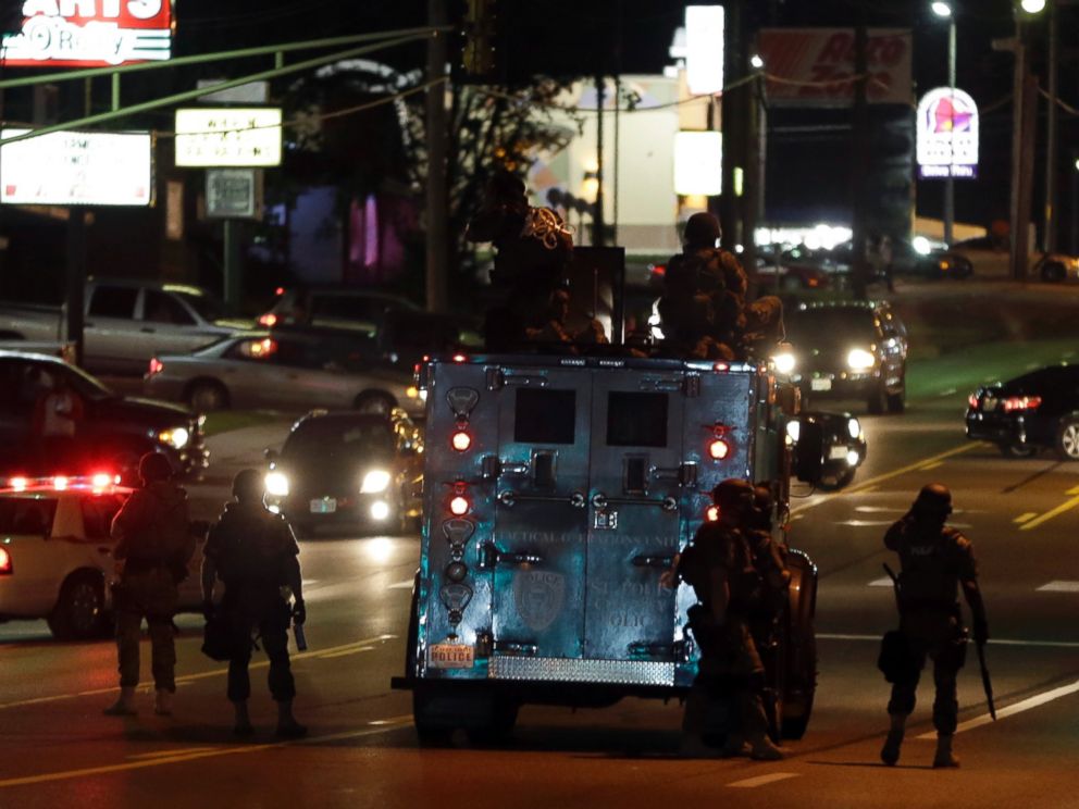PHOTO: Police attempt to secure a street after a clash with protesters, Aug. 13, 2014, in Ferguson, Mo.