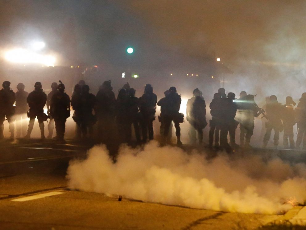 PHOTO: Police advance through smoke, Aug. 13, 2014, in Ferguson, Mo.