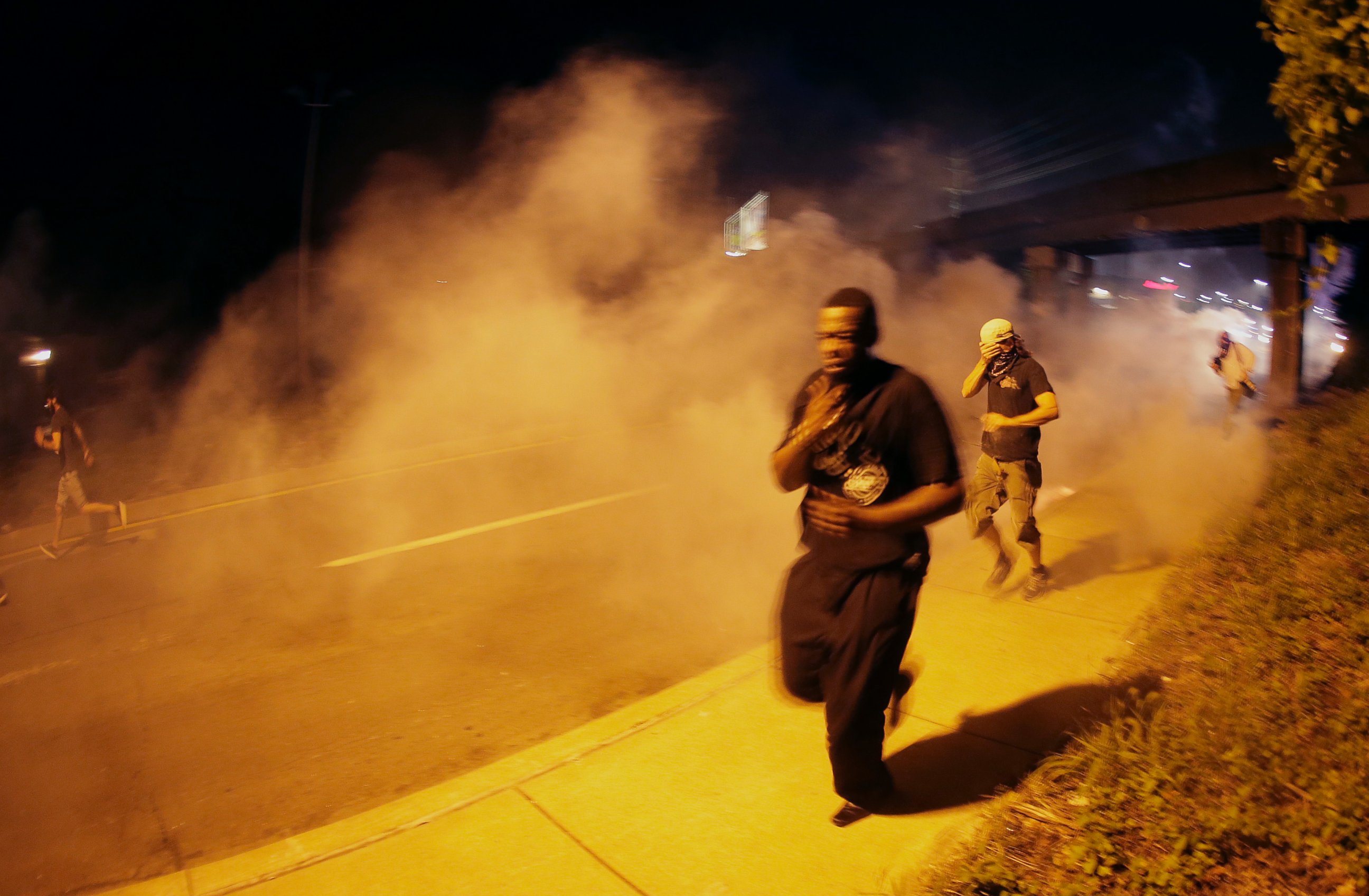PHOTO: People run after police fired tear gas in Ferguson, Mo., Aug. 17, 2014.