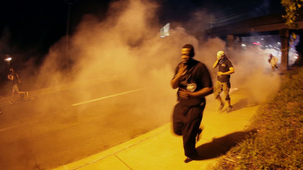 PHOTO: People run after police fired tear gas in Ferguson, Mo., Aug. 17, 2014.