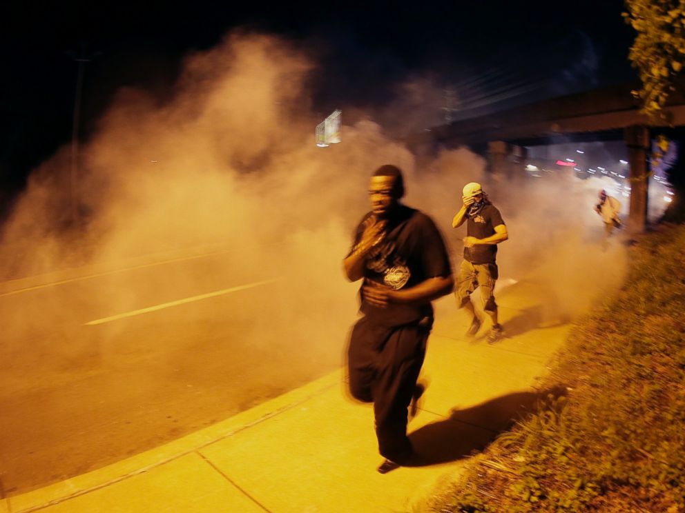 PHOTO: People run after police fired tear gas in Ferguson, Mo., Aug. 17, 2014.