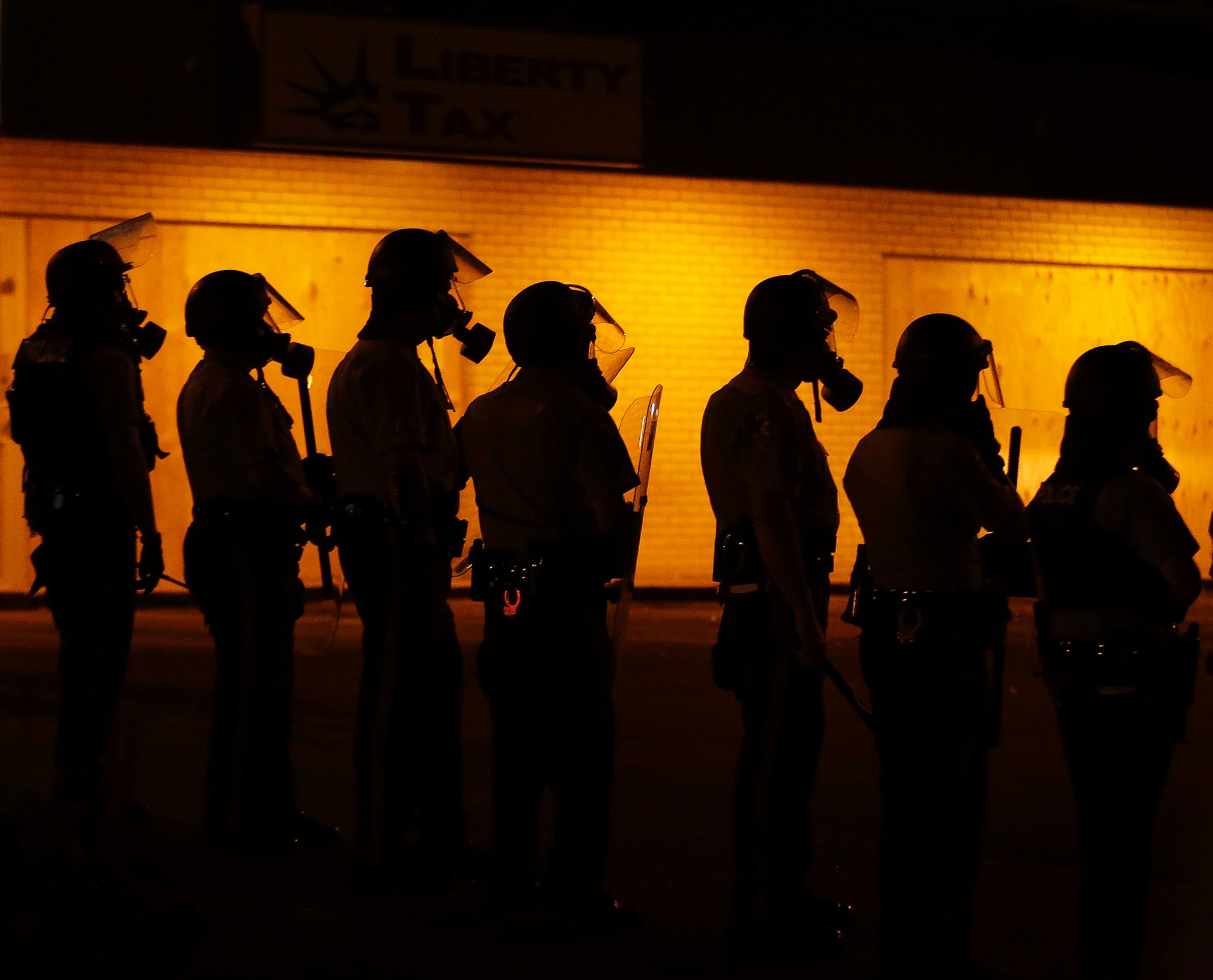 PHOTO: Police wait to advance after tear gas was used to disperse a crowd in Ferguson, Mo., Aug. 17, 2014.