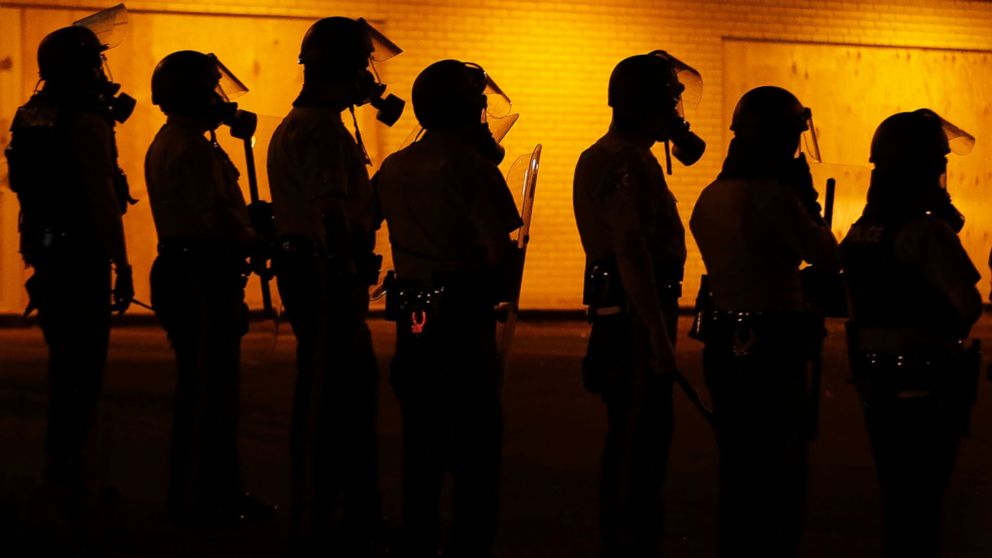 PHOTO: Police wait to advance after tear gas was used to disperse a crowd in Ferguson, Mo., Aug. 17, 2014.