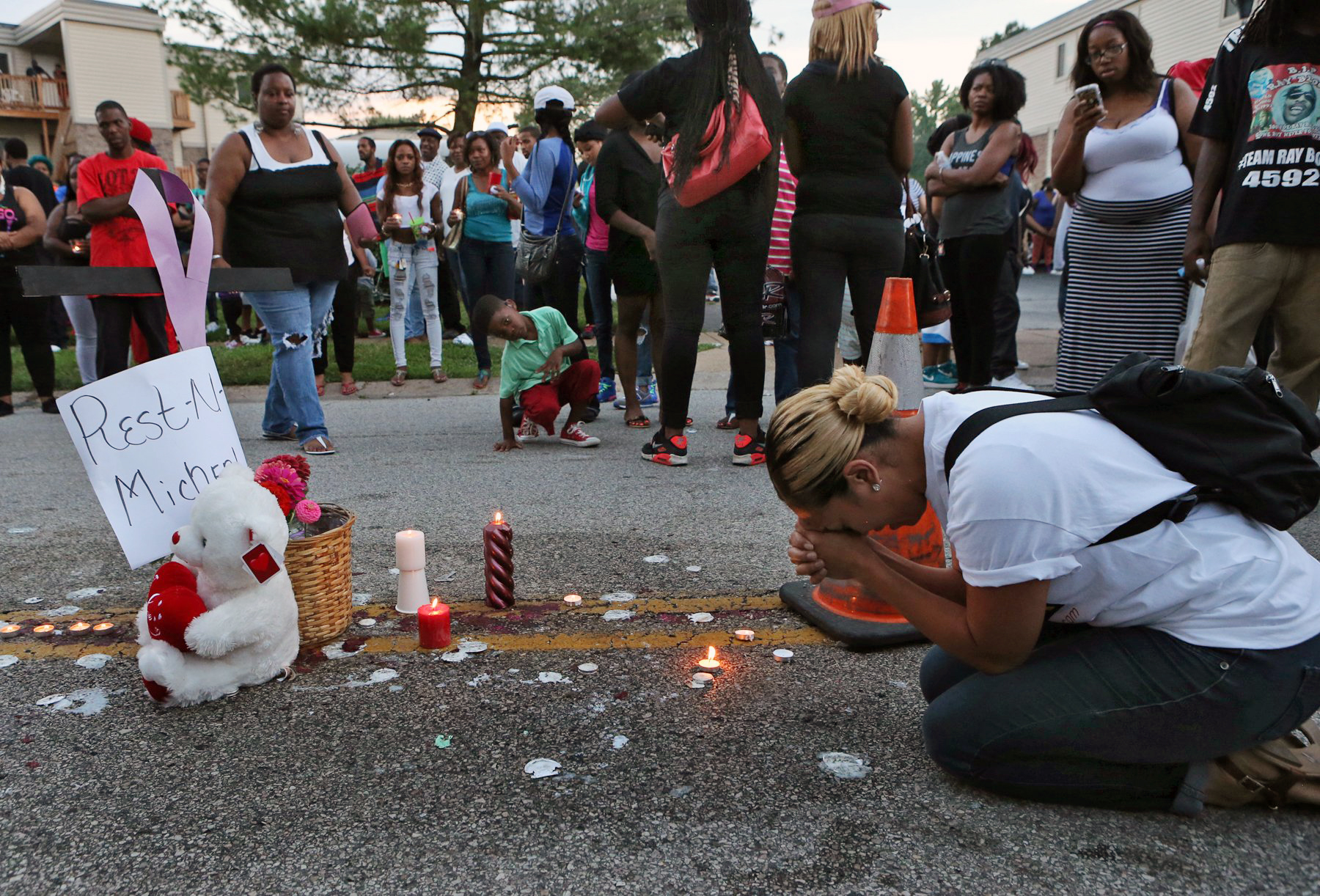 PHOTO: Meghan O'Donnell, 29, from St. Louis, prays at the spot where Michael Brown was killed, Aug. 10, 2014, in Ferguson, Mo.